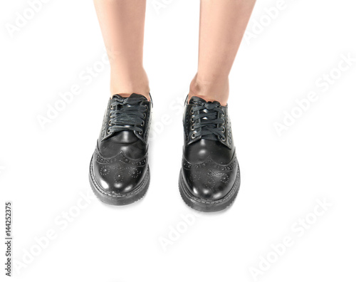 Foto Legs in stylish black brogue shoes on light background