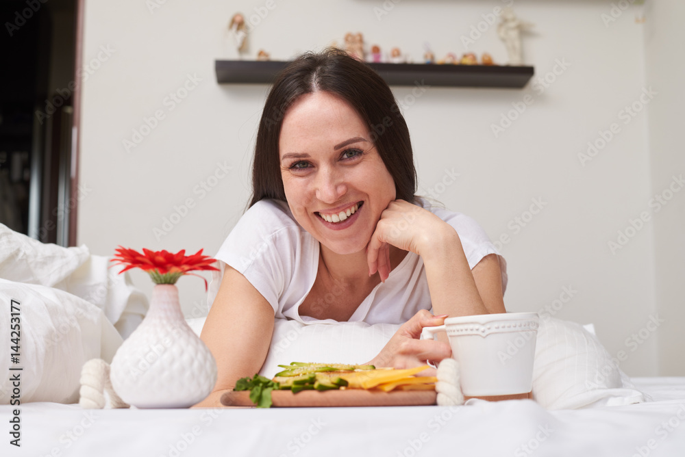 Smiling woman being pleased with breakfast