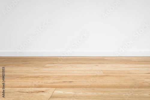 new wooden floor - parquet floor and white wall background 