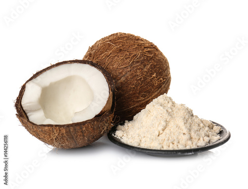 Plate with heap of coconut flour and nuts on white background