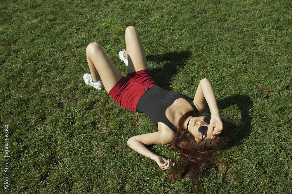 Young woman lying on grass Stock Photo | Adobe Stock