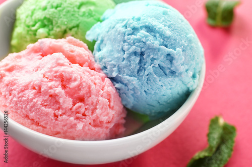 Trio of tasty ice cream in bowl on color background