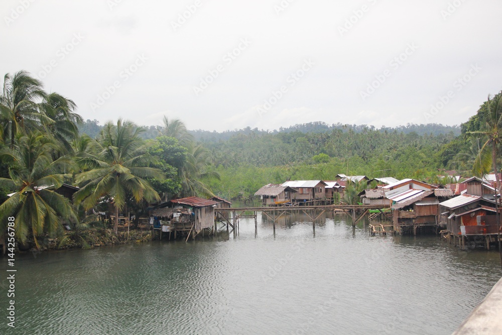 Houses by the riverside, Southern Philippines Houses on stilts in a fishing village in Lianga, Surigao del Sur, Philippines