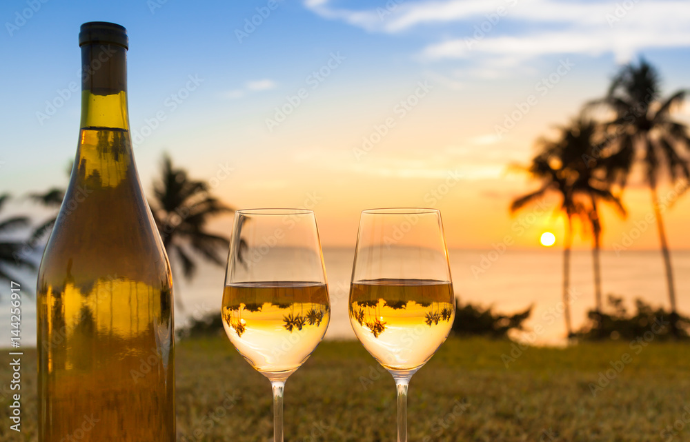 Romantic beach holiday retreat concept. Pair of wine glasses against a beautiful sunset. (location Hawaii) 