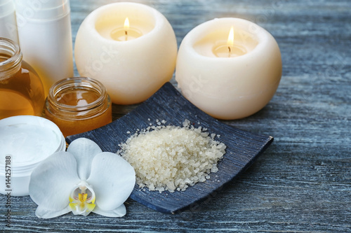 Spa setting with aroma candles  delicious honey and sea salt on grey wooden table