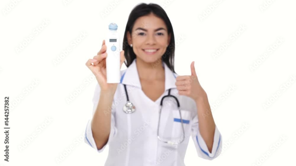 Smiling young woman nurse showing device for measuring temperature and gesture thumb up isolated Smiling young woman nurse showing device for measuring temperature and gesture thumb up isolated