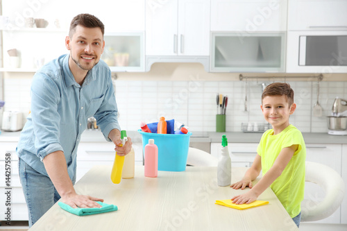 Dad and son doing cleaning at home © Africa Studio