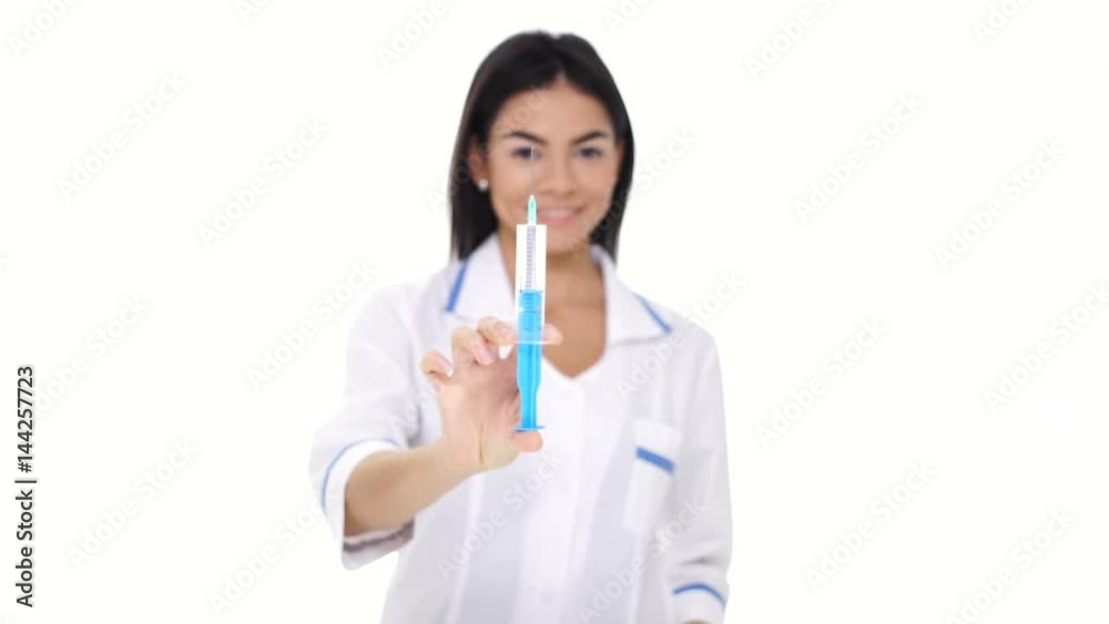Woman nurse wearing white lab coat with stethoscope showing syringe isolated Woman nurse wearing white lab coat with stethoscope showing syringe isolated