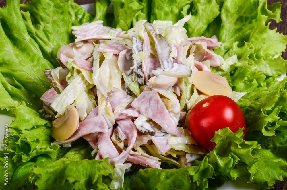 Salad with ham and mushrooms on a lettuce leaf