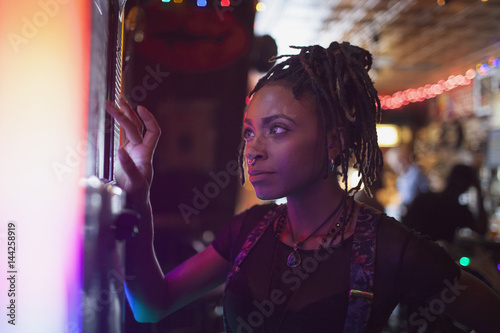 A young woman at a jukebox in a bar. photo