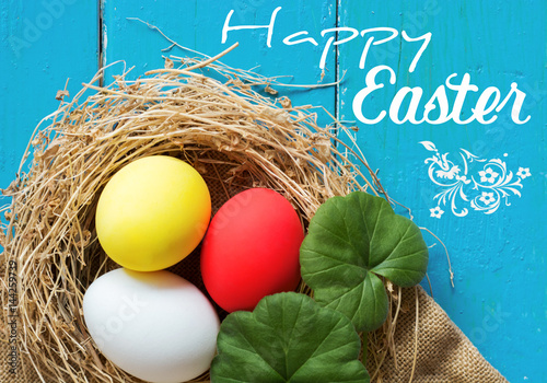 Happy Easter Card.  Colored eggs in nest on wooden, selective focus image.  
