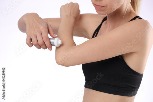 Woman suffering from elbow ban applying pain relief cream