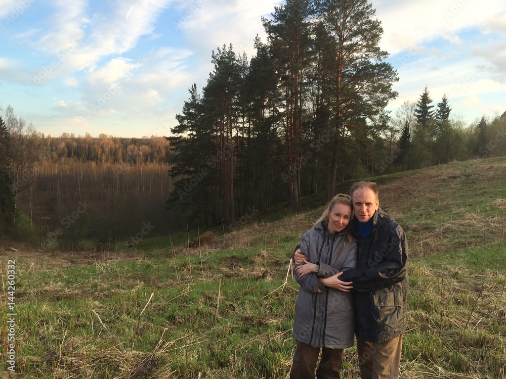 the man and the woman in country clothes on a background of early spring Pine hill
