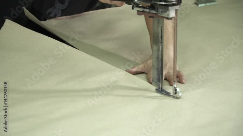 A large machine for cutting fabrics. Cutting fabric machine. Sewing production line. Textile factory.