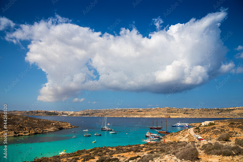 Blue Lagoon, Malta - Beautiful clouds over malta's famous Blue Lagoon on the island of Comino with the island of Gozo and Mgarr town at the background on a bright sunny summer day