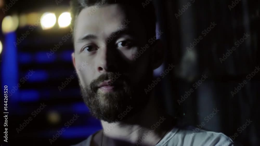 Portrait of a concentrated young man with a beard and a fashionable hairdo in a nightclub during a rock band musical performance. Low key shot. Portrait of a concentrated young man with a beard and a fashionable hairdo in a nightclub during a rock band musical performance. Low key shot.