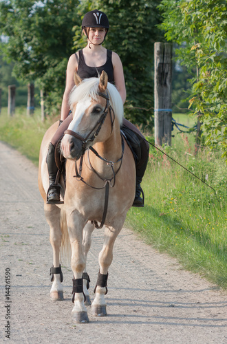 A young woman riding a horse Haflinger © patrikslezak
