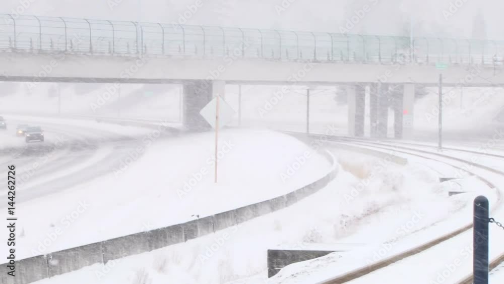 Camera pan on cars driving on freeway during snow storm. Camera pan on cars driving on freeway during snow storm.