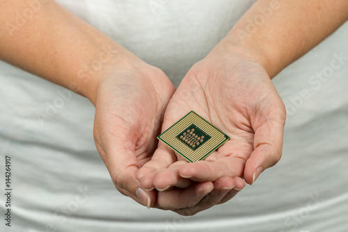 Female holding a computer CPU in her hands with a very shallow depth of field and focus on the processor