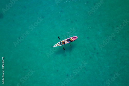 Aerial Photo - top down view of a canoe with unknown people in the middle of the turqoise sea © hafizismail