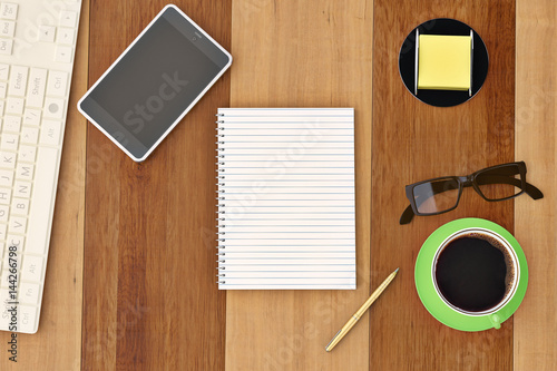 Office desk with notebook glasses keyboard coffee cup and phone top view on wood background.3D illustration.