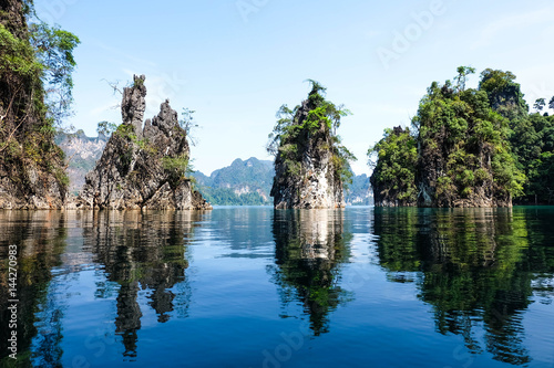 Three moutains island with green tree and blue sky at Ratchaprapa Dam in Thailand, mirror or shadow of water and double image of mirage concept