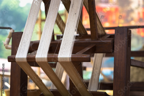 Weaving silk in traditional way with manual loom in Vietnam, closeup