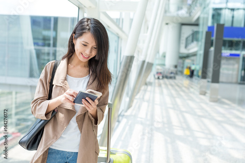 Woman checking on cellphone at Hong Kong airport