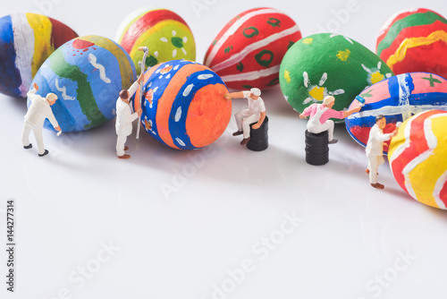 miniature people painting easter eggs