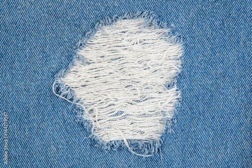 blue jean texture with a hole and threads showing