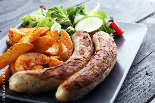 grilled sausages and potatoes and salad photo