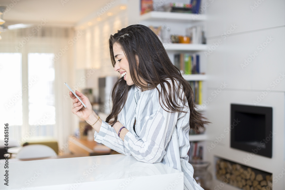 Young woman with phone at home. Morning scene Young woman with phone at home. Morning scene