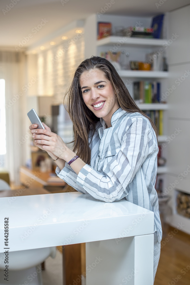 Young woman with phone at home. Morning scene Young woman with phone at home. Morning scene