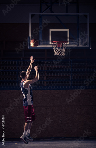 Basketball player shooting, indoors court