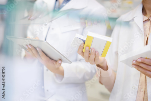 Pharmacists taking stock with digital tablet