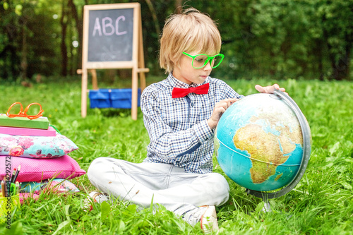 Boy examines the globe. Teaches geography. The concept of traini photo