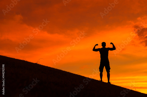 Fototapeta Naklejka Na Ścianę i Meble -  Silhouette of strong and confident man flexing. 