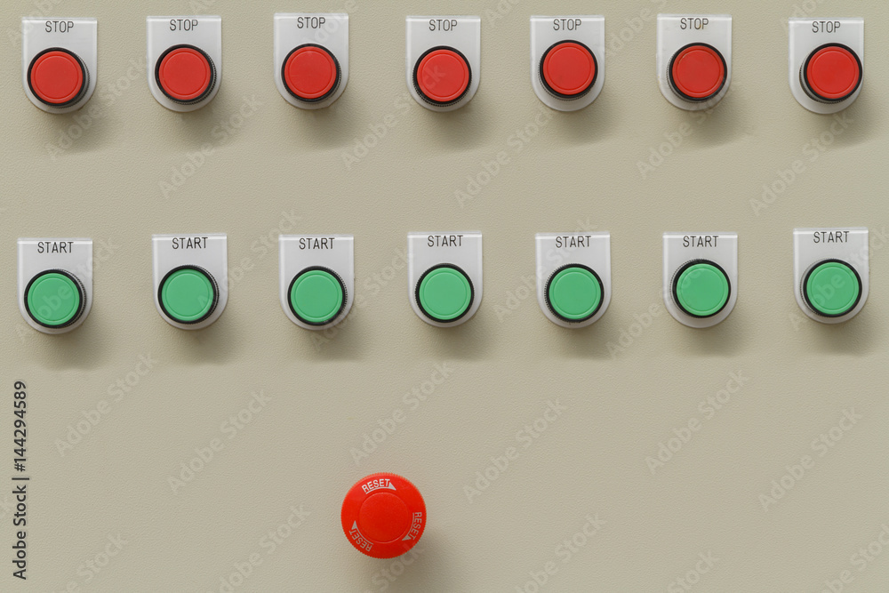 Red emergency and stop switch with green start buttons on control panel ...