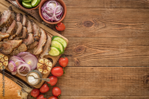 Sliced grilled meat barbecue on cutting board with vegetable .