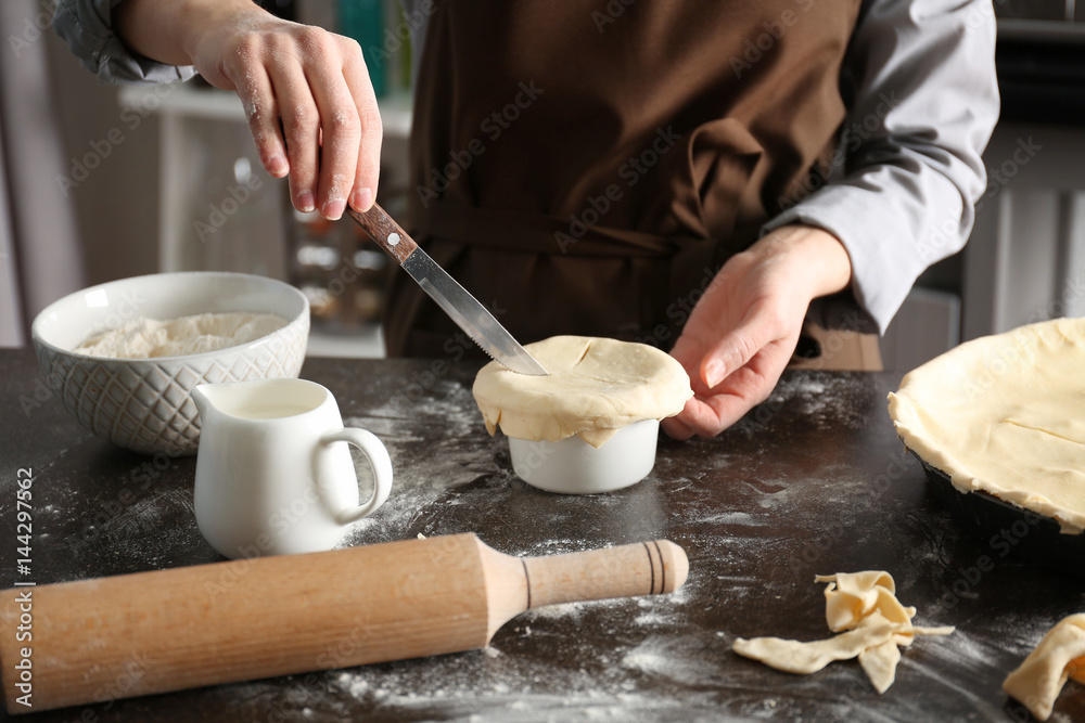 Woman making delicious chicken pot pie on kitchen table Woman making delicious chicken pot pie on kitchen table