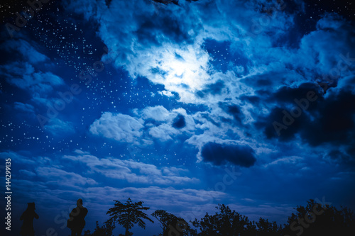 Attractive of amazing blue dark night sky with stars and cloudy above field of trees.