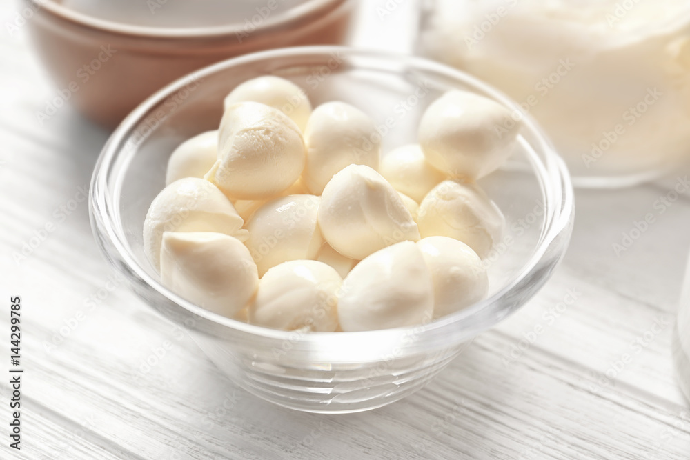 Glass bowl with mozzarella on wooden table, closeup Glass bowl with mozzarella on wooden table, closeup