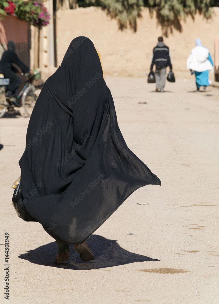 A woman in a burka Burqa walking down a middle eastern street Stock ...