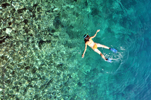 Young woman snorkeling in transparent shallow sea
