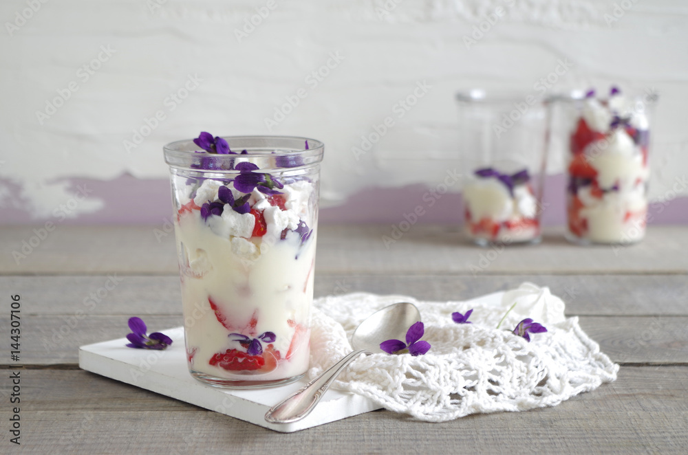 Erdbeer-Schicht-Dessert mit Vanillecreme, Baiser und Veilchen Stock ...