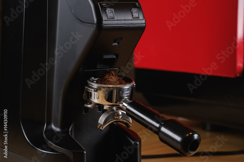 Black electric grinder is on a wooden table
