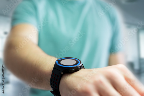 Hand holding black smartwatch with technology screen