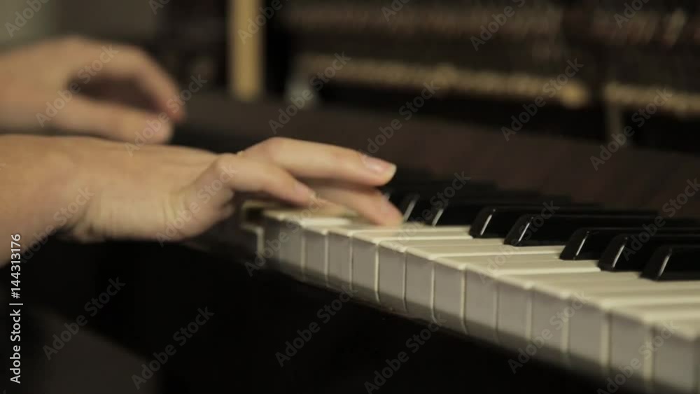 close-up female hands playing piano on a dark close-up female hands playing piano on a dark