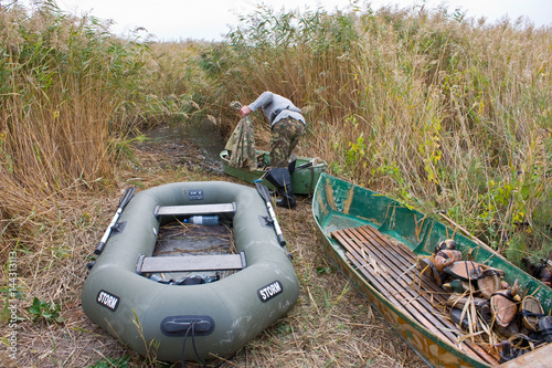 Billede på lærred Hunting boats with a hunting rifle and stuffed ducks