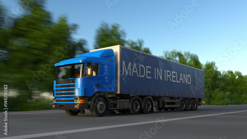 Speeding freight semi truck with MADE IN IRELAND caption on the trailer. Road cargo transportation. 3D rendering